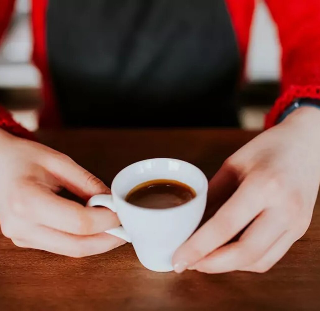 Mujer sujetando taza de café espresso